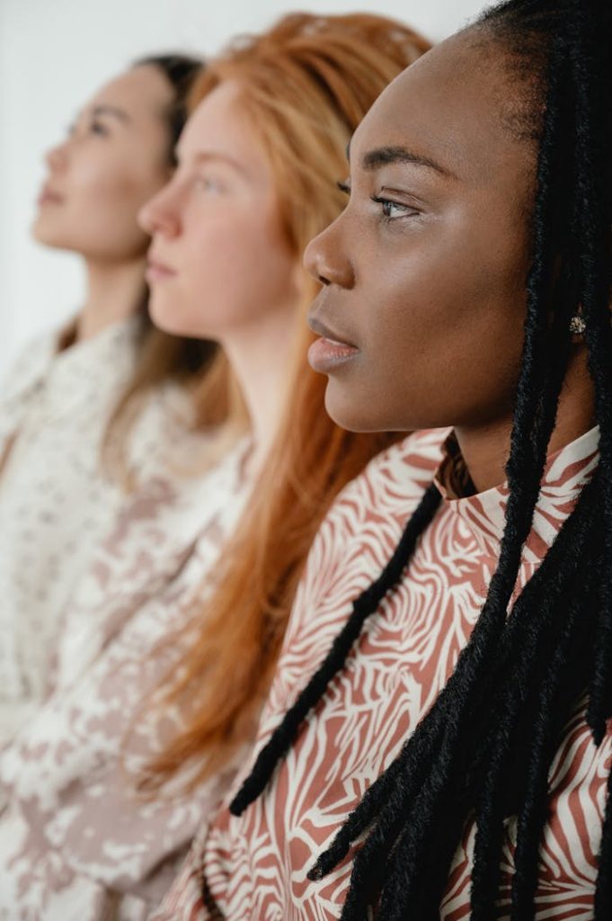 Portrait of three diverse women in profile, showing unity and diversity.