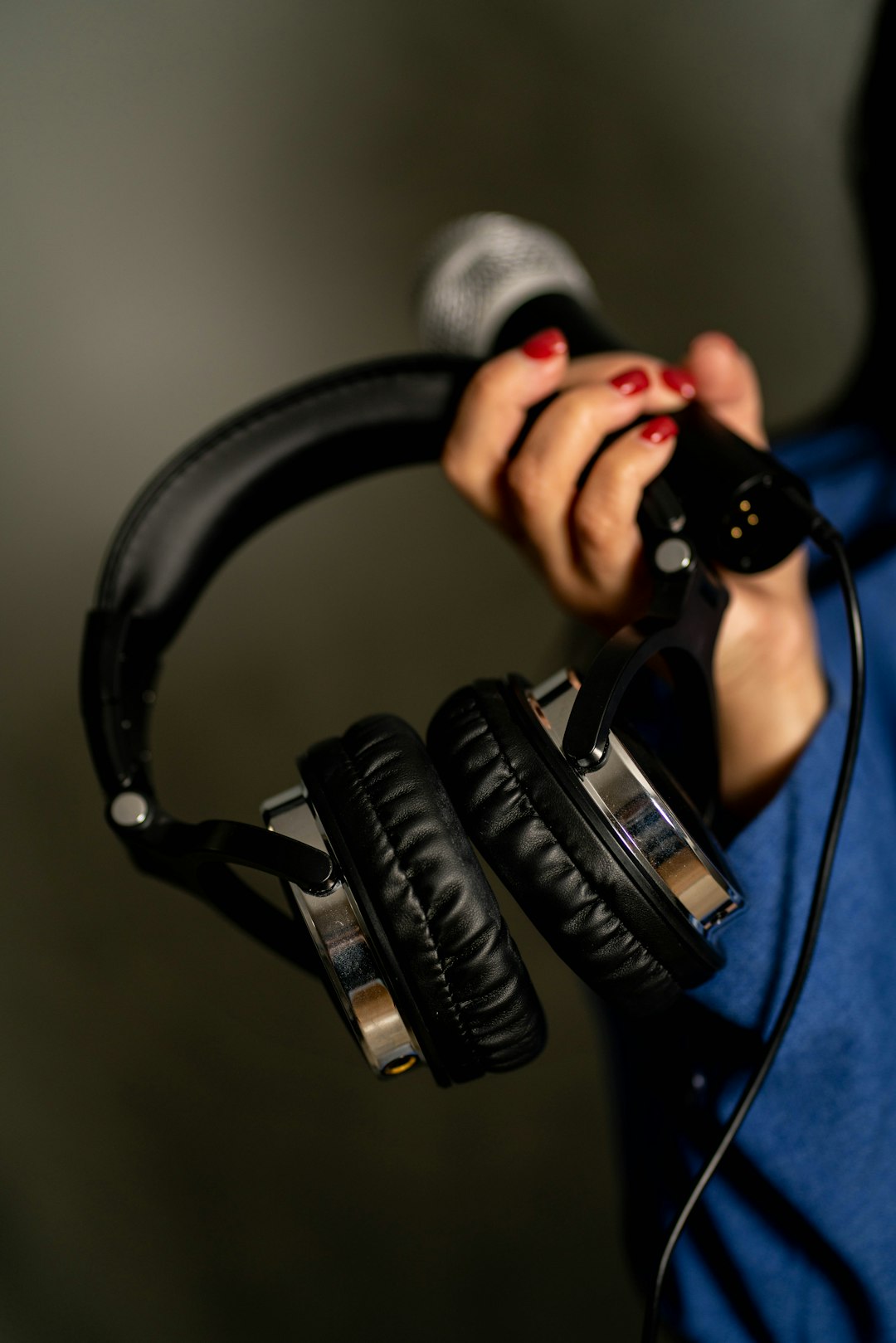a-woman-holding-a-pair-of-headphones-in-her-hands-2yher543ysk